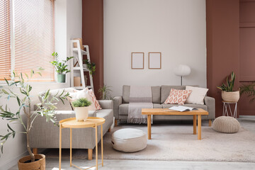 Interior of stylish living room with grey sofas, houseplants and coffee table