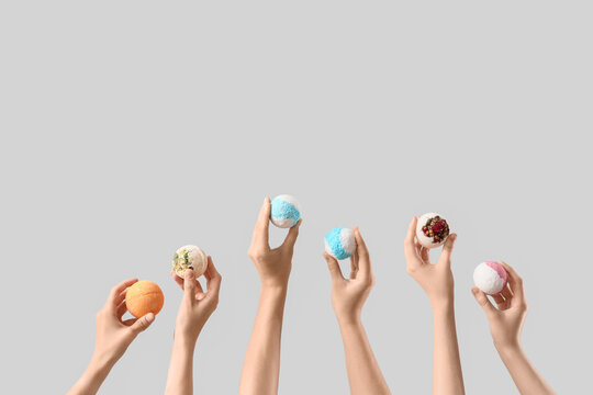 Female hands with different bath bombs on white background - Powered by Adobe