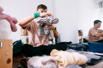 Affectionate father interacts gently with child near unpacked bags