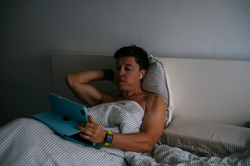 Youthful individual checks device as older person rests peacefully