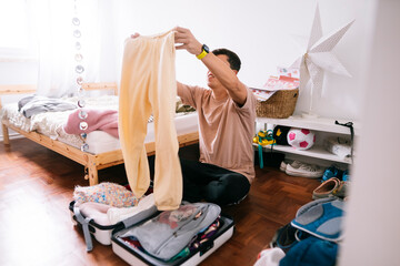 Young man carefully arranging belongings for travel in sunlight