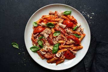 Pasta penne with tomatoes and tuna. Top view with copy space.