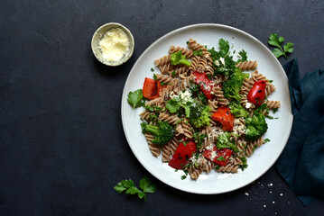 Whole grain pasta fusilli with grilled vegetable and parmesan cheese. Top view with copy space.