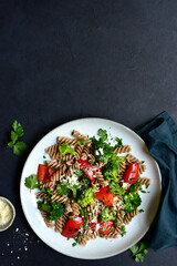Whole grain pasta fusilli with grilled vegetable and parmesan cheese. Top view with copy space.