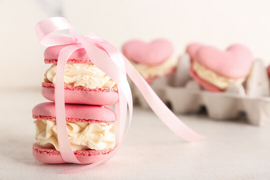 Sweet heart-shaped macaroons tied with ribbon on white background. Valentine's Day celebration