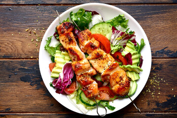 Chicken kebab skewers with vegetable salad. Top view with copy space.