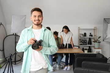 Smiling male photographer with camera during courses in studio