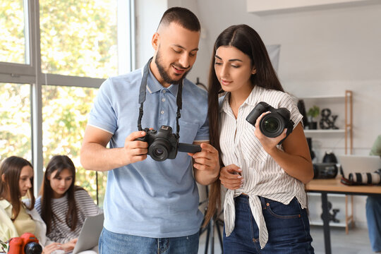 Young photographers with cameras during courses in studio