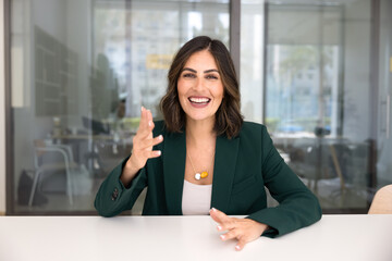Obraz premium Cheerful Hispanic business professional woman talking on video conference call