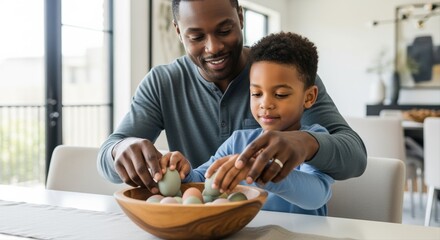 father enjoying quality time painting eggs with son in bright modern kitchen interior