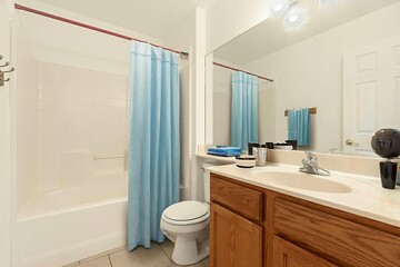 A bathroom that includes a toilet, sink, and a shower curtain present