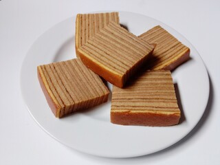 close-up of indonesian layer cake lapis legit slices on white plate.