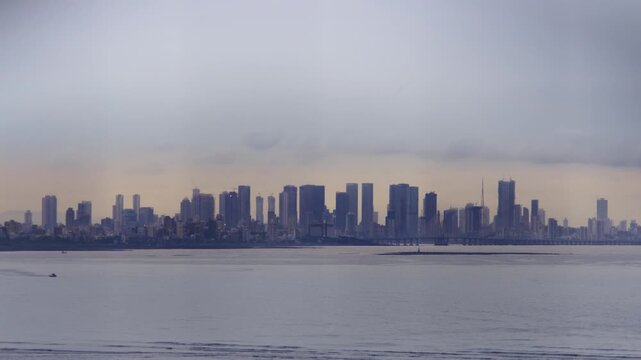A beautiful shot of the city skyline of the developing urban financial district, modern skyscrapers or high-rise buildings during sunset in the evening, by the coast of the Arabian Sea, Mumbai, India