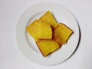 slice of bika ambon cake. close-up bika ambon indonesian traditional honeycomb cake on white plate.