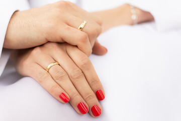 Groom Hand Holding Bride Hand With Red Nails On White Wedding Dress. Wedding Rings. Marriage Commitment And Romantic Connection Close-Up