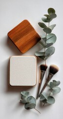 Flat lay makeup compacts, brushes, eucalyptus branches
