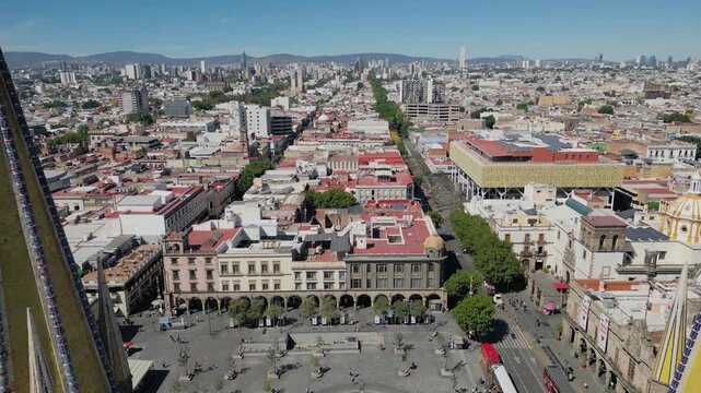 Aerial footage retreating to show Guadalajara Cathedral with Plaza Tapatia and the surrounding cityscape in view