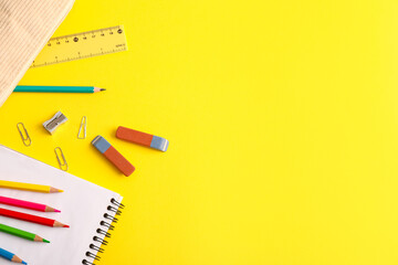 Erasers with different stationery on yellow background