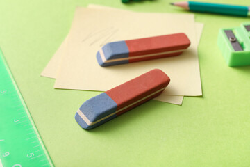 Erasers with stationery on green background