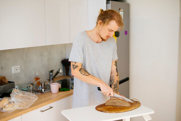 Trimmed for safety, Man cuts sourdough bread amid rustic setting
