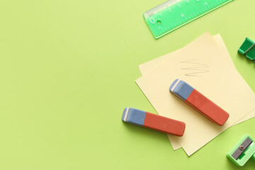 Erasers with stationery on green background