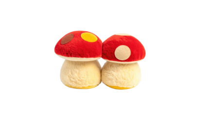 Two plush mushrooms with red caps and tan stems sit closely on a black background