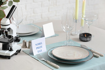 Elegant table setting for Nobel prize day with microscope and candles in dining room