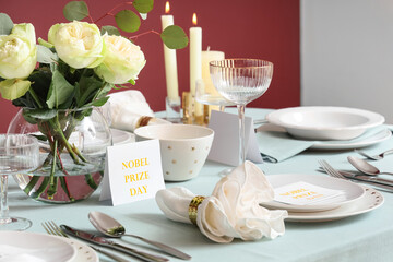 Beautiful table setting for Nobel prize day with flowers and candles in dining room