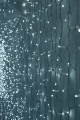  Background of Glowing Christmas lights on a white surface. Vertical photo.