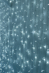  Background of Glowing Christmas lights on a white surface. Vertical photo.