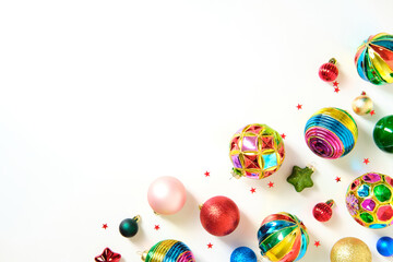 Vibrant Christmas ornaments and stars arranged on a white background with copy space.
