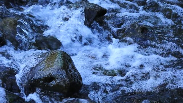 Fast-flowing clear river water and boulders. Jamor River, Oeiras, Portugal.