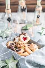 Variety of christmas cookies on a table with christmas decoration in the background
