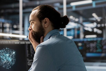 Data scientist in server room reviewing software algorithms using neural network displayed on computer. IT expert analyzing dashboard visualization metrics at workstation in data center
