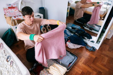 young asian man packing pink sweater as thoughtful gift