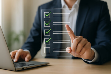 Corporate employee checking completed items on interactive digital checklist while working with laptop to ensure efficient workflow tracking