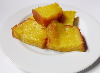 slice of bika ambon cake. close-up bika ambon indonesian traditional honeycomb cake on white plate.