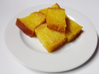 slice of bika ambon cake. close-up bika ambon indonesian traditional honeycomb cake on white plate.