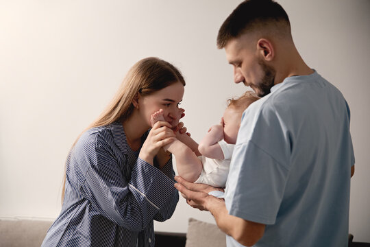 Loving parents joyfully interacting with their baby in a cozy home environment, showcasing affection and family bonding, parenting moments, family love concept