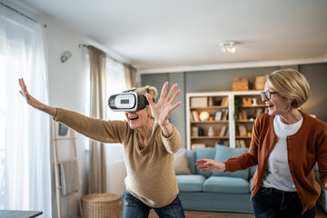 Senior women exploring virtual reality headset technology, having fun