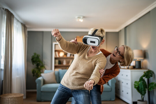 Senior women playing virtual reality video game at home