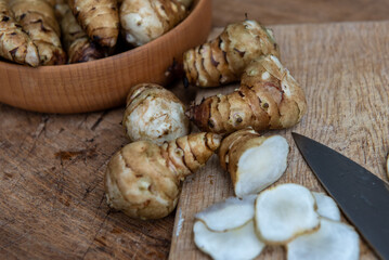 Fresh Sliced Jerusalem Artichokes on Wooden Cutting Board