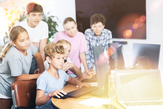 Group of children students learning to use computer in classroom