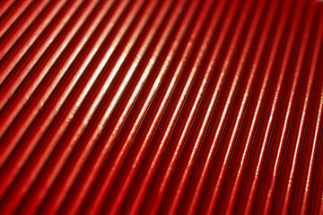abstract red metallic texture with rhythmic reflective ridges and dynamic light highlights