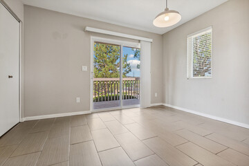 An empty living room featuring a sliding glass door and a window