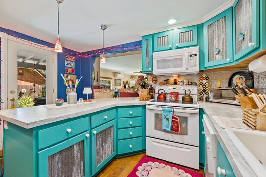 A vibrant kitchen interior showcasing beautiful teal cabinets