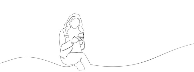 A woman is sitting and using a smartphone in one continuous line. single line art style vector illustration. Editable stroke.