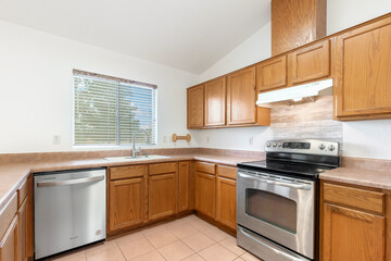 Fototapeta premium A modern kitchen with stainless steel appliances and wooden cabinets