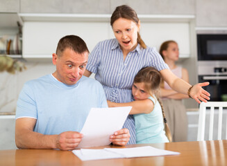 Obraz premium Wife yells at her husband who has not paid the loan. Children are upset and scared