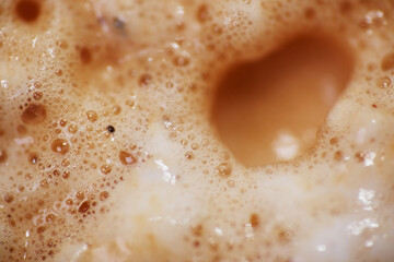 Top view of creamy milk coffee froth. Milk foamer is essential to most coffee beverages such as...